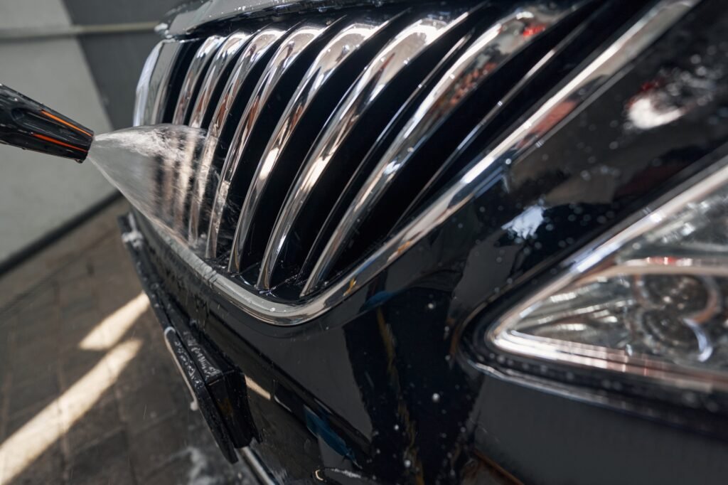 Photo of washing car radiator grille with high pressure spray